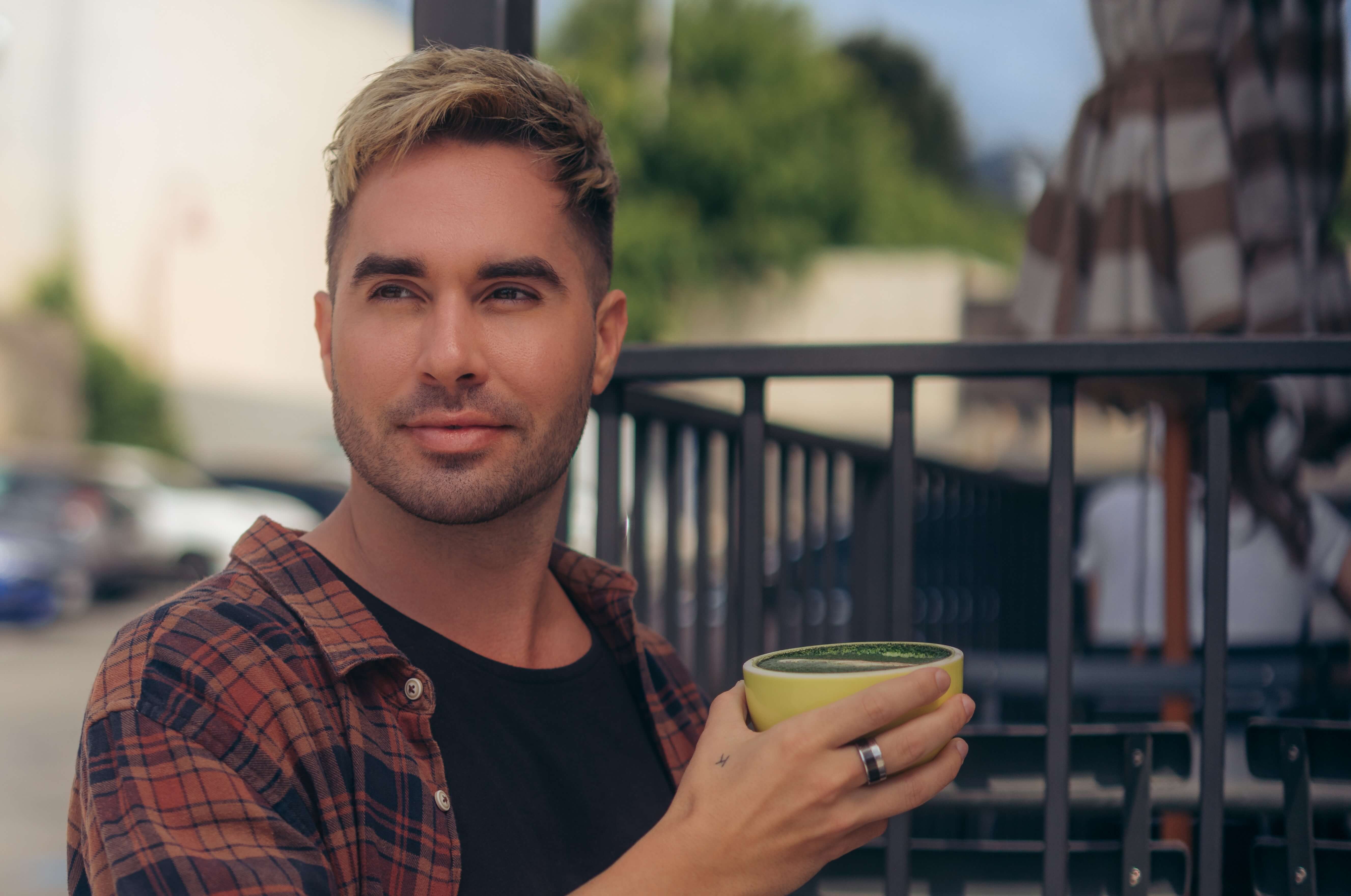 Man with blonde hair holding a cup