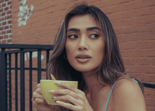 Woman with wrinkle-free skin holding a cup of coffee