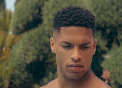 Photo of a male model surrounded by greenery